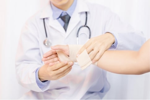 male doctor putting gauze young man s hand clinic closeup first aid